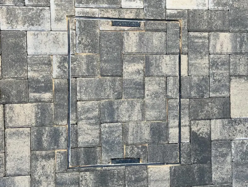 Side walkway of blended grey block paving with a charcoal soldier edge and linear drain along the house wall.